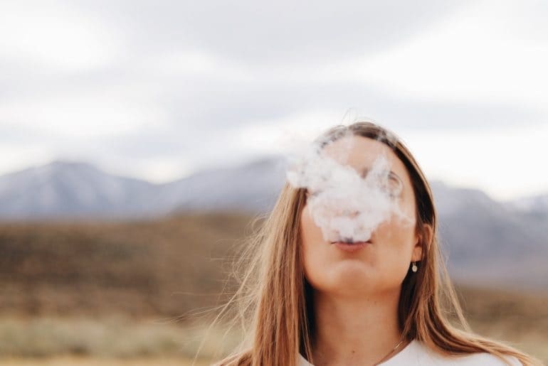 Woman in white shirt cannabis blowing